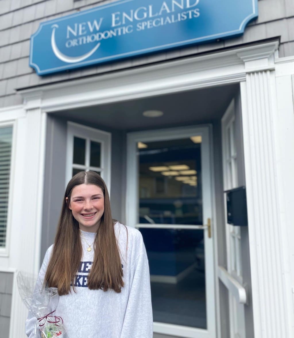New England Orthodontic Office and young patient at the entrance