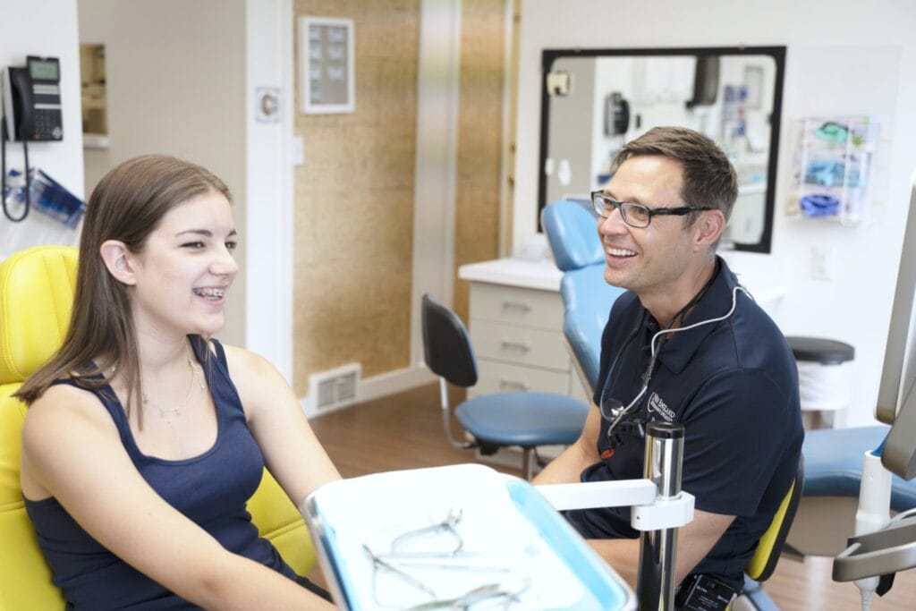 a teen receiving orthodontic treatment in a dental chair.